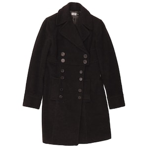 May include: A black double-breasted coat featuring a wide collar, long sleeves, and two rows of dark buttons extending down the front. The coat has a structured silhouette with two rectangular pockets positioned on the lower front section.