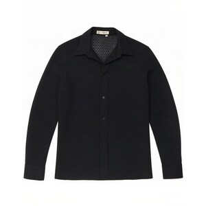 May include: A long-sleeved black button-down shirt featuring a subtle, repeating geometric textured pattern throughout the fabric, a classic pointed collar, and a small white label with black text located at the inside of the neckline.