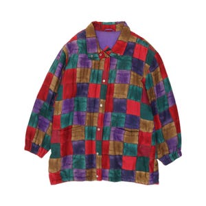 May include: A long-sleeve button-up jacket featuring a multi-colored checkered pattern in shades of red, purple, green, and brown. The garment has a pointed collar, a front placket with silver-toned metal buttons, and a solid purple inner lining.