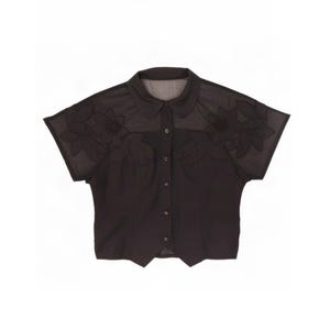 May include: A black short-sleeved button-down shirt featuring a semi-sheer yoke with tonal floral embroidery across the chest and shoulders. The garment has a classic collar, a front button placket, and a pointed hemline at the waist.