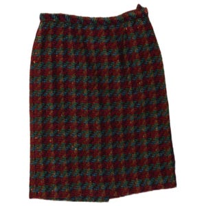 Puede incluir: Una falda hasta la rodilla con un patrón de pata de gallo multicolor en tonos rojo intenso, azul oscuro y verde bosque. La prenda cuenta con una cintura elástica y un cierre de un solo botón situado en la parte superior derecha de la cintura.