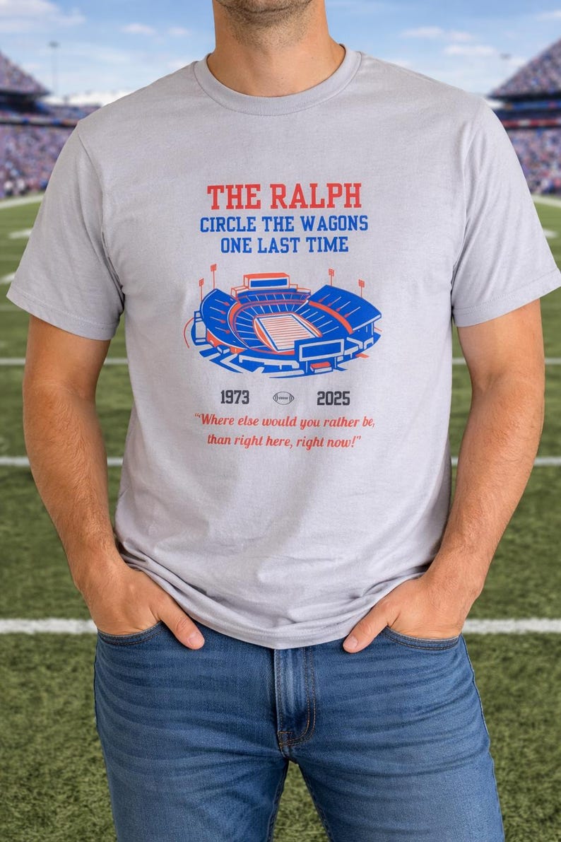 Man wearing a gray Buffalo Bills shirt featuring “The Ralph – Circle the Wagons One Last Time” stadium graphic with 1973–2025 tribute, standing on a football field background.