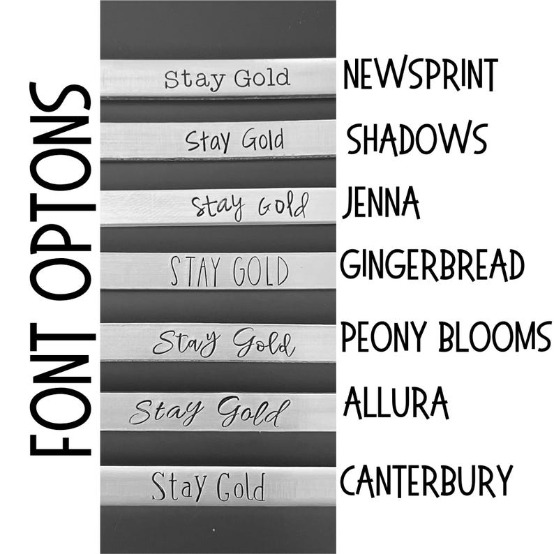 May include: A display of seven silver-coloured metal strips, each engraved with the text Stay Gold in a different font style. The font names are listed to the right as NEWSPRINT, SHADOWS, JENNA, GINGERBREAD, PEONY BLOOMS, ALLURA, and CANTERBURY.