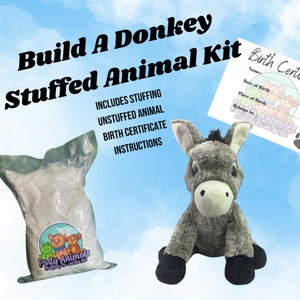 May include: A Build A Donkey Stuffed Animal Kit includes stuffing, an unstuffed donkey plush, a birth certificate, and instructions. The donkey plush is gray with black hooves. The kit's packaging features the text "Build A Donkey Stuffed Animal Kit".