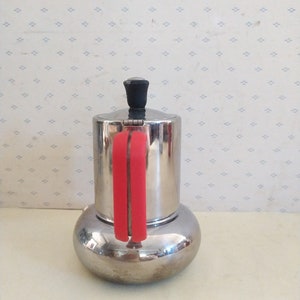 May include: A silver and red stovetop espresso maker with a red handle.