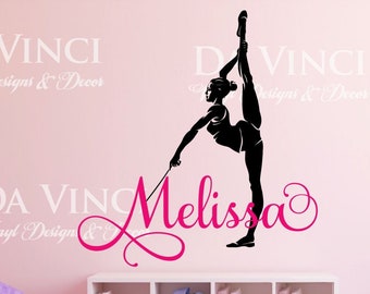 May include: A pink wall with a black silhouette of a gymnast holding a ribbon. The gymnast's name, "Melissa", is written in pink cursive lettering. The text "DA VINCI Vinyl Designs & Decor" appears in white at the top and bottom of the image.