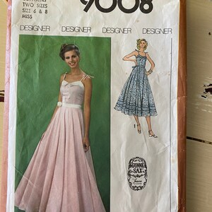 Puede incluir: Patr&oacute;n de costura Simplicity n&uacute;mero 9008 para un vestido. El patr&oacute;n incluye dos tallas, 6 y 8, para se&ntilde;oritas. El patr&oacute;n es para un vestido largo y fluido con un corpi&ntilde;o ajustado y una falda completa. El vestido se muestra en dos telas diferentes, un estampado floral rosa y un estampado floral blanco.