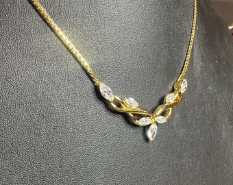 May include: A gold chain necklace with a delicate design featuring clear marquise-shaped stones. The stones are set in a leaf-like pattern, creating a feminine and elegant look.