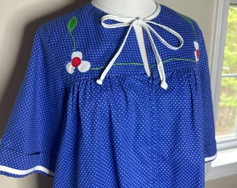 May include: A blue and white polka dot robe with a white trim and a white bow tie. The robe has embroidered flowers with red centers and green leaves.