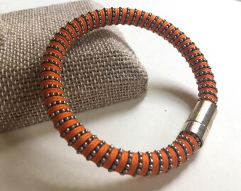 May include: Orange and silver beaded bracelet with a magnetic clasp.