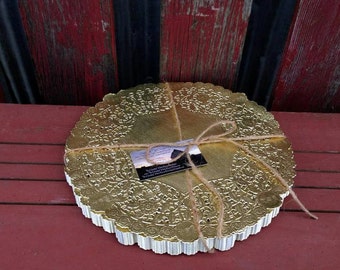 May include: A stack of gold-colored paper doilies with a delicate lace pattern. The doilies are tied together with twine.