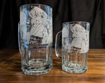 May include: Two clear glass beer mugs of different sizes, each featuring a white etched graphic of an anime-style character wearing traditional clothing. The mugs have sturdy handles and thick bases, with the character design wrapping around the glass.