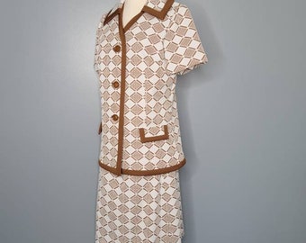 May include: A white and brown geometric patterned skirt suit with a short-sleeved jacket and a skirt. The jacket has a brown collar and brown trim around the edges. The skirt has a brown waistband and brown trim around the bottom.