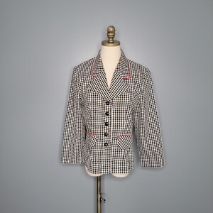 May include: A black and white gingham blazer with red trim. The blazer has a button-up front and long sleeves.