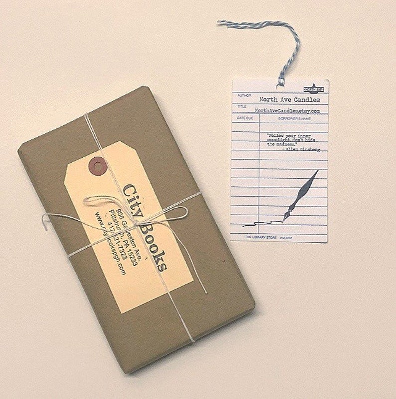 May include: A brown paper-wrapped book with a City Books label and a white library card bookmark with the text "Follow your inner moonlight, don't hide the madness" - Allen Ginsberg.