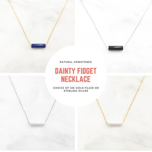 May include: Dainty gold filled or sterling silver necklace with a natural gemstone bar pendant. Choose from lapis lazuli, black onyx, or white howlite.