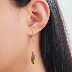 以下が含まれることがあります： 涙型のオパール宝石が付いたゴールドのドロップイヤリング。オパールは赤、オレンジ、黄、緑、黒のミックスです。