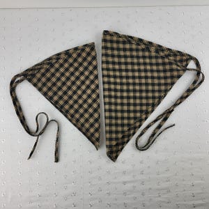 以下が含まれることがあります： 黒とベージュのチェック柄のバンダナ2枚。長い紐が付いています。バンダナは三角形で、柔らかい生地で作られています。チェック柄はクラシックなデザインで、ヘッドウェアやネックウェアとして使用される可能性があります。