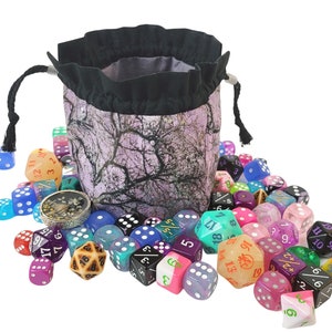May include: A purple and black fabric dice bag with a drawstring closure, spilling out a variety of colorful dice with different numbers and symbols.