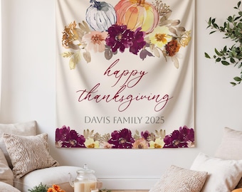 May include: A cream-colored Thanksgiving tapestry with watercolor pumpkins, flowers, and the text "happy thanksgiving" and "DAVIS FAMILY 2025". The design features a floral border.