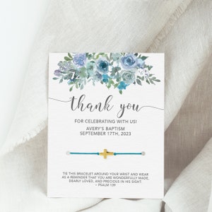 May include: A thank you card with a blue floral design and a blue bracelet with a gold cross charm. The card says "Thank you for celebrating with us! Avery's Baptism September 17th, 2023". The bracelet has a tag that says "Tie this bracelet around your wrist and wear as a reminder that you are wonderfully made, dearly loved, and precious in his sight. - Psalm 139"