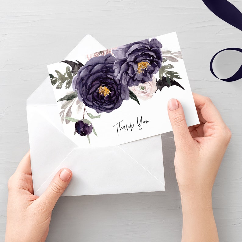 May include: A white thank you card with a watercolor floral design featuring dark purple and light pink flowers. The text "Thank You" is written in black cursive.