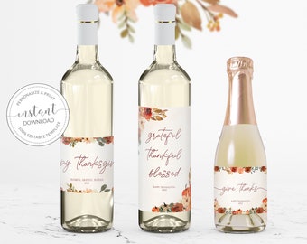 May include: Three wine bottle labels with a fall theme. The labels feature a watercolor floral design with pumpkins and the text "by Thanksgiving", "grateful thankful blessed", and "give thanks".