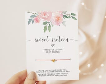 May include: A white card featuring a watercolor floral design of pink roses and green leaves at the top. The text reads sweet sixteen, thanks for coming! love, charlie, and instructions for a pink string bracelet with a small gold heart charm.