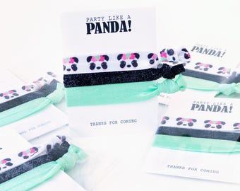 May include: A set of panda-themed hair ties with a white card that reads "PARTY LIKE A PANDA!". The hair ties feature a panda face pattern, black glitter, and mint green colors. The card also says "THANKS FOR COMING".