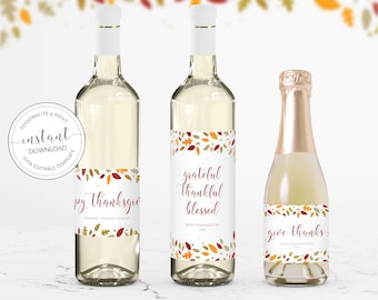 May include: Three wine bottles with labels featuring fall leaf designs and the phrases "happy thanksgiving", "grateful thankful blessed", and "give thanks". The labels are white with red and orange text.