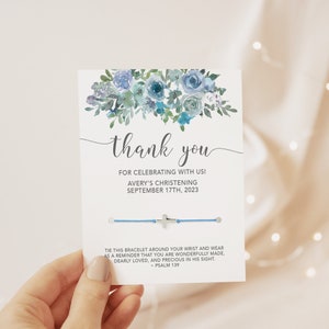 May include: A blue and white floral thank you card with a blue bracelet and a silver cross charm. The card says "Thank you for celebrating with us! Avery's Christening September 17th, 2023". The back of the card says "Tie this bracelet around your wrist and wear as a reminder that you are wonderfully made, dearly loved, and precious in His sight. - Psalm 139"
