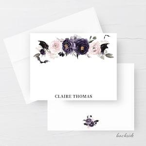 May include: White stationery set featuring a floral design with dark purple and light pink flowers, and black bats. The name "CLAIRE THOMAS" is printed in black. The backside of the card has a small floral design and the word "backside".