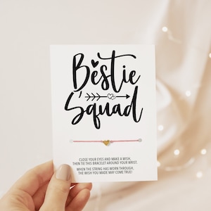 Peut inclure: Bracelet d'amitié rose avec un charme en forme de cœur doré. La carte indique "Bestie Squad" et comprend des instructions pour faire un vœu et attacher le bracelet autour de votre poignet. Lorsque la ficelle est usée, votre vœu peut se réaliser.
