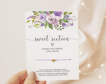 May include: A white card featuring a purple floral illustration at the top, the text sweet sixteen, a heart icon, and the message thanks for coming! love, malisa. A light purple string bracelet with a small gold heart charm is attached.
