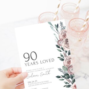 May include: A white invitation card with a floral design in shades of pink and green. The text on the card reads "90 Years Loved" and "Please join us for a birthday celebration honouring Selena Smith". The date of the event is listed as "08.24.21" and the time is "at seven o'clock in the evening". The location is listed as "12345 10th Avenue San Francisco, CA".