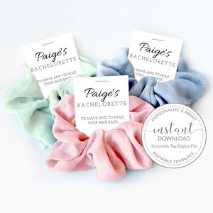 May include: Three pastel-colored scrunchies with white tags that say "Paige's Bachelorette" and "To have and to hold your hair back". The tags are attached to the scrunchies with a small piece of clear tape. The scrunchies are light blue, light green, and pink.