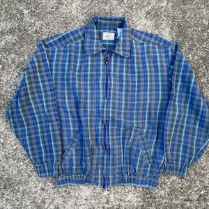 May include: A blue and green plaid zip-up jacket with a drawstring waist.