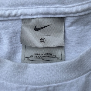 May include: White t-shirt with a Nike logo and a tag that reads "Made in Mexico of U.S.A. components" and "XL".