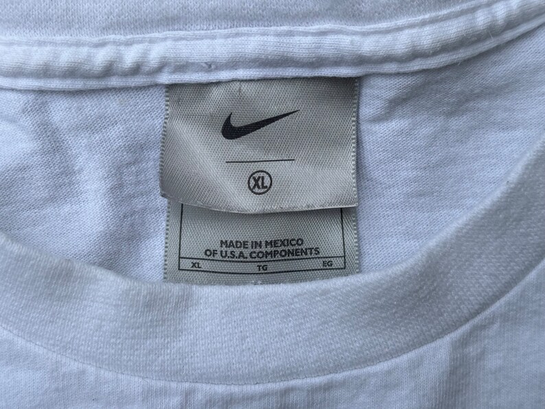 May include: White t-shirt with a Nike logo and a tag that reads "Made in Mexico of U.S.A. components" and "XL".