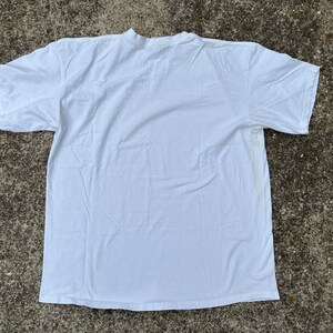 May include: A plain white t-shirt with short sleeves and a crew neck.