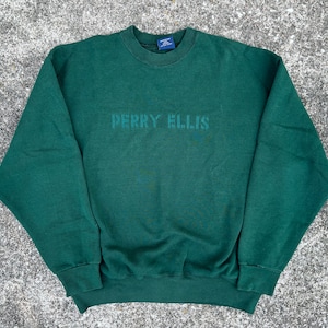 May include: A dark green sweatshirt with the text "PERRY ELLIS" printed on the front.