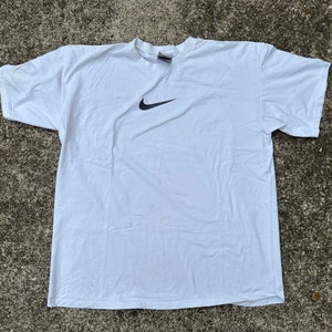 May include: White t-shirt with a black Nike swoosh logo.