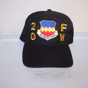 May include: A black baseball cap with a gold embroidered "20FW" and a blue, red, and yellow patch that reads "Victory by Valor".