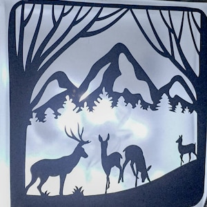 May include: Silhouette of a deer family in a woodland setting with mountains in the background. The deer are black against a white background.