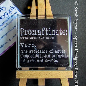 May include: A black and white definition of the word "Procraftinate" on a small wooden easel. The definition reads: "(Proh-kraf-tuh-neyt) Verb. The avoidance of adult Responsibilities to partake in Arts and Crafts."