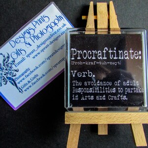 May include: A black and white definition of the word "Procraftinate" on a small wooden easel. The definition is "The avoidance of adult Responsibilities to partake in Arts and Crafts."