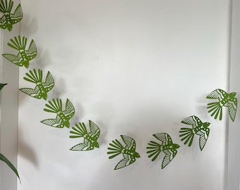 Guirnalda de papel con golondrinas voladoras de color verde pistacho para decoración de pared.