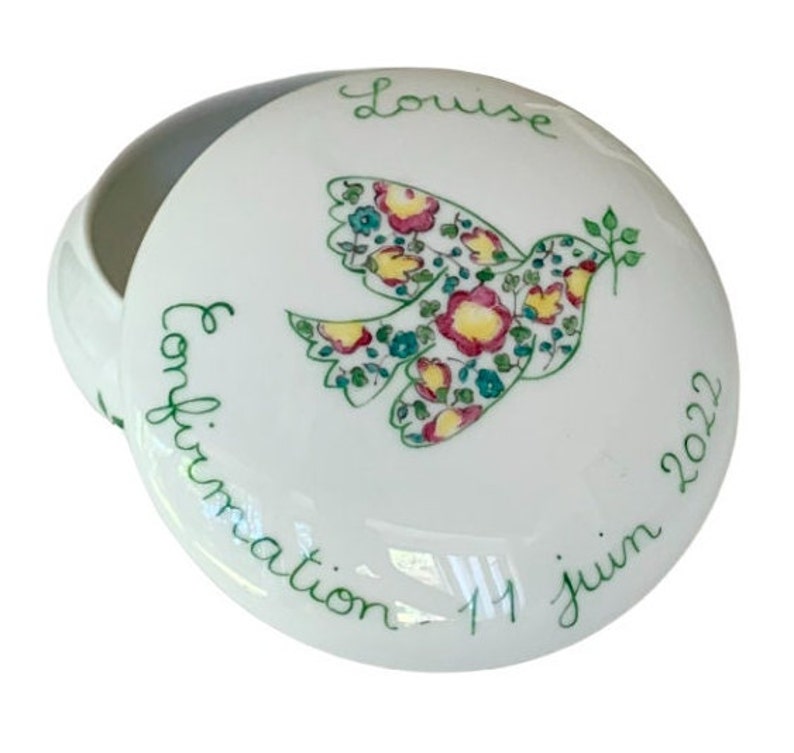 May include: White ceramic keepsake box with a dove design and the text "Confirmation 11 Juin 2022" and "Louise" on the lid.
