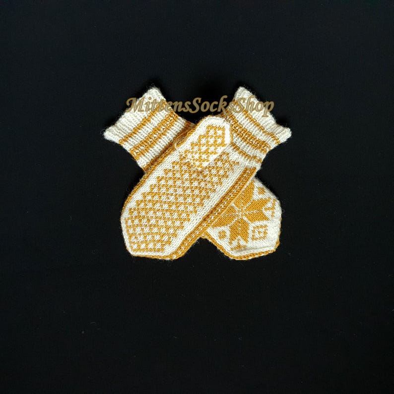 May include: A pair of white knitted mittens with a yellow geometric pattern. The mittens are folded in half and the pattern is visible on both sides.