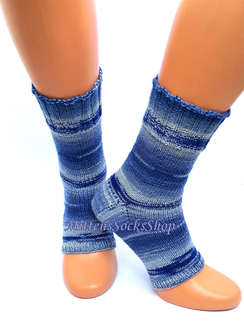 A pair of blue and white striped hand knit yoga socks with heel  with a light blue and white color gradient. The socks are made of a soft, comfortable sock yarn and are perfect for everyday wear. The socks are on a pair of mannequin feet.